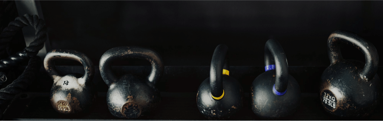 row of kettlebells and other sports equipment