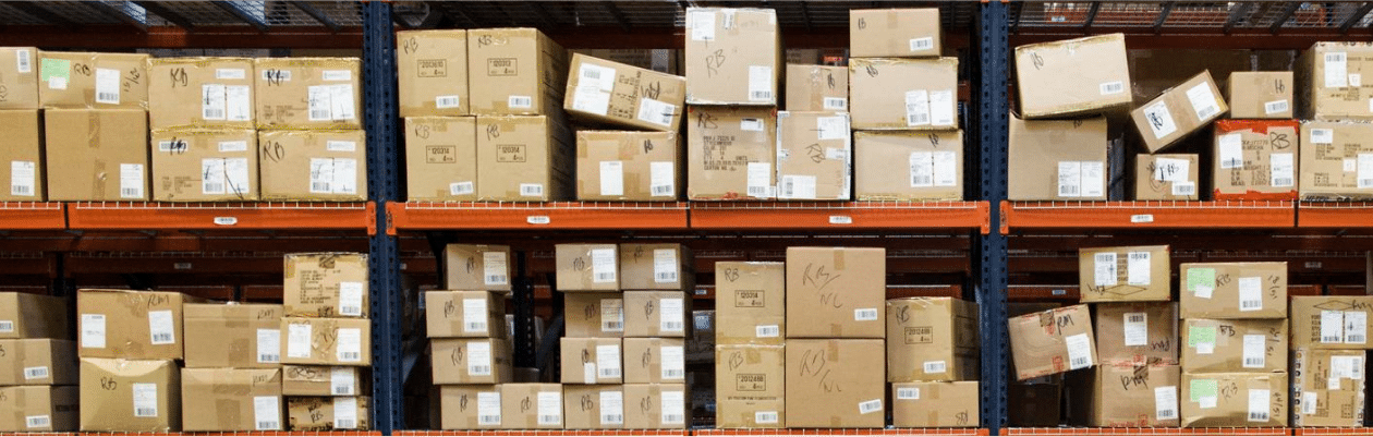 Cardboard boxes stacked on metal shelves in a warehouse